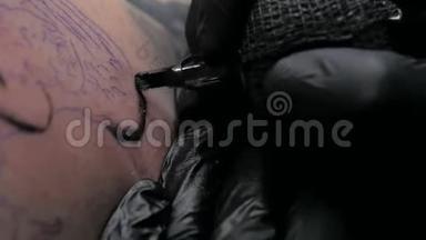 近距离纹身艺术家展示了一个客户背上有油漆的黑色纹身的过程